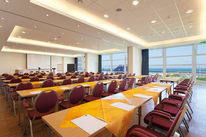 Konferenzraum mit Meerblick Großer, heller Konferenzraum mit Stuhlreihen und gedeckten Tischen, Blick aufs Meer.