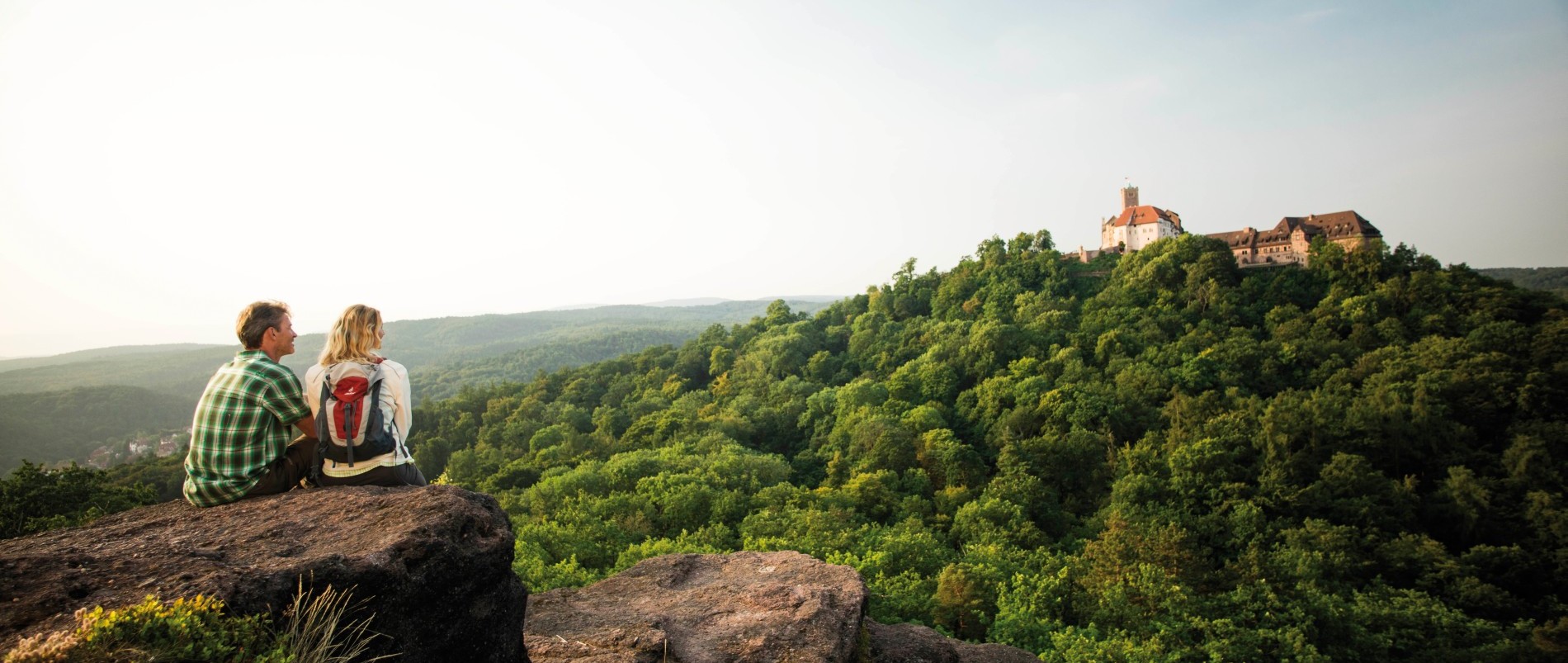 Panorama des Domplatzes in Erfurt mit dem Erfurter Dom und der Severikirche im Hintergrund, sowie ein Denkmal im Vordergrund.