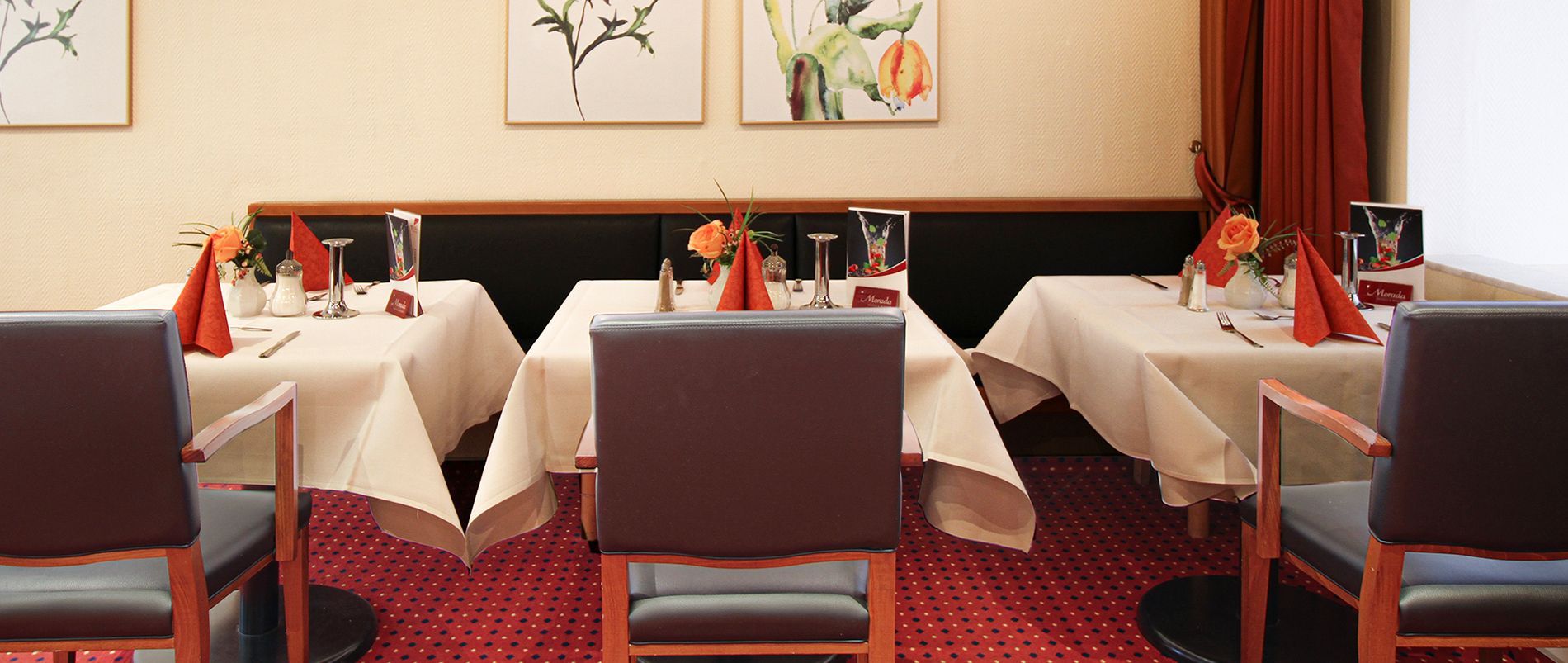 Elegantes Restaurant mit gedeckten Tischen und Dekorationen.